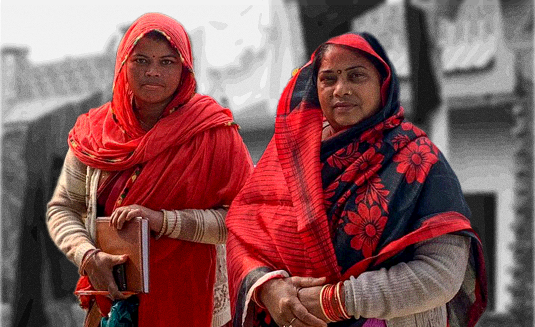 Two community health workers wearing red look into the camera—a photo clicked by Newsworthy.Studio's Anubha Bhonsle for PARI women's health series.