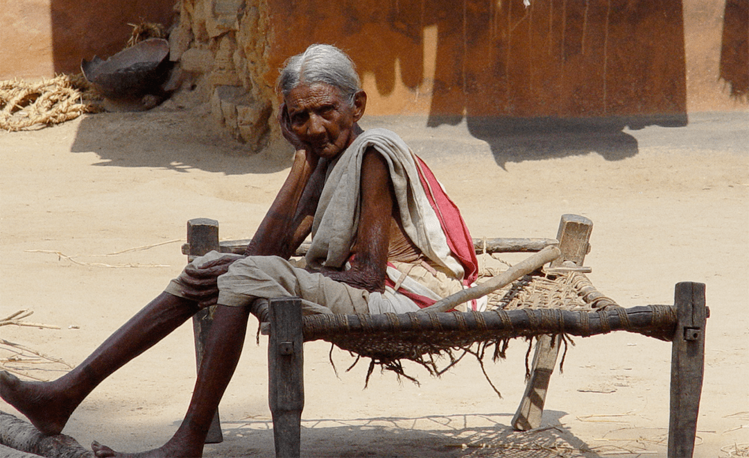 An image of an old woman sitting on a charpai - highlighting gender upclose for UPES